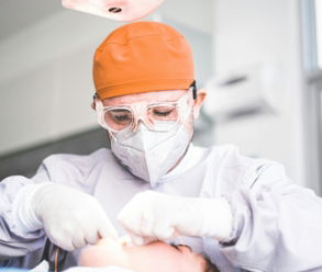 a man getting his teeth brushed by a dentist